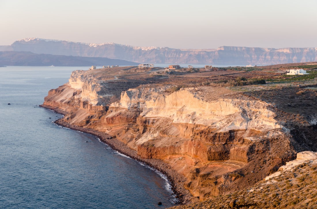 "Un cratère à l'ouest de l'archipel du Mont Santorin, à cap Akrotiri. On y voit affleurer la roche rouge faite d'ignimbrites. Crédit : Wikimedia commons"